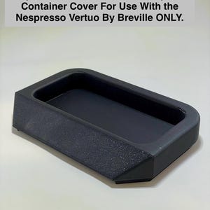 May include: Black plastic replacement water or used capsule container cover for Nespresso Vertuo by Breville.