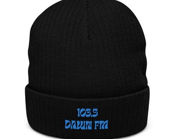 Puede incluir: Gorro negro de punto acanalado con el texto "103.5 DAWN FM" bordado en azul. El gorro es de estilo clásico, adecuado para el clima frío. El sombrero está hecho de un material suave y cómodo.