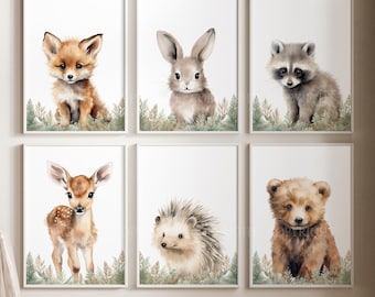 May include: A set of six framed wall art prints featuring watercolour illustrations of a fox, a rabbit, a raccoon, a fawn, a hedgehog, and a bear cub. Each animal is depicted sitting amidst green foliage against a plain white background.