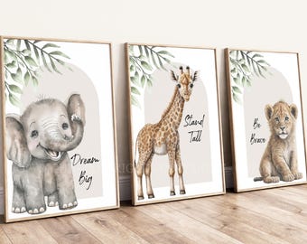 May include: Three framed wall art prints featuring watercolor illustrations of a baby elephant, a giraffe, and a lion cub. Each print includes green leaf accents, a beige arch background, and the text Dream Big, Stand Tall, and Be Brave.