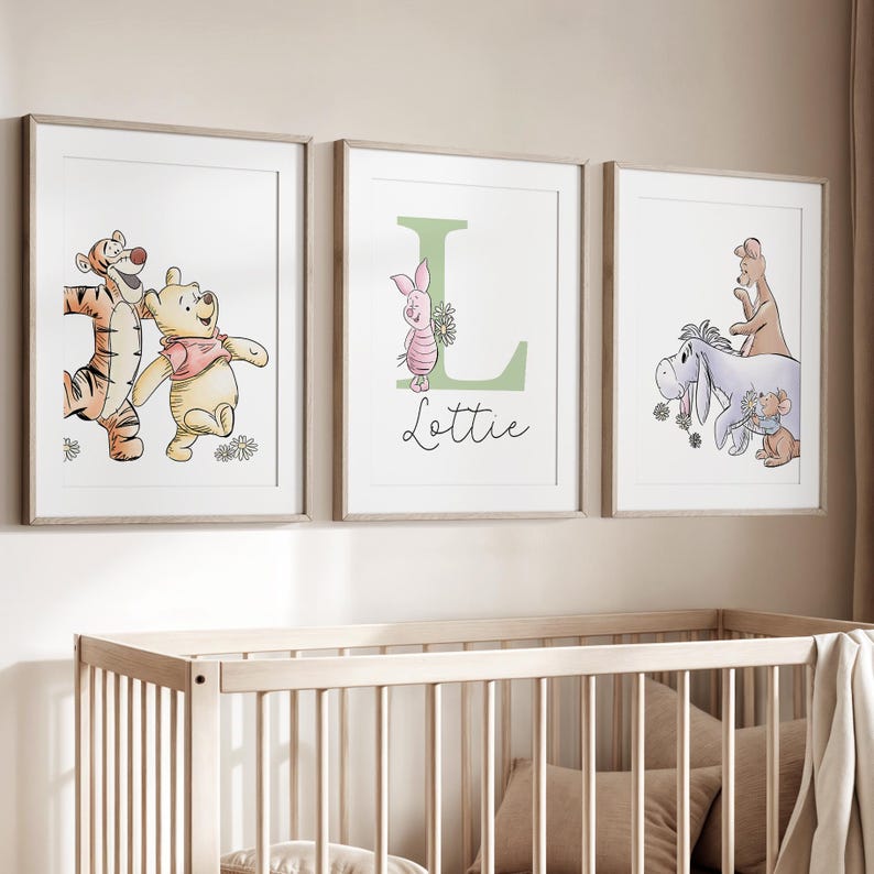 May include: Three framed wall art prints featuring Winnie the Pooh characters. The left print shows Tigger and Pooh. The center print features a large green letter L, Piglet, and the name Lottie. The right print shows Eeyore, Roo, and Kanga.