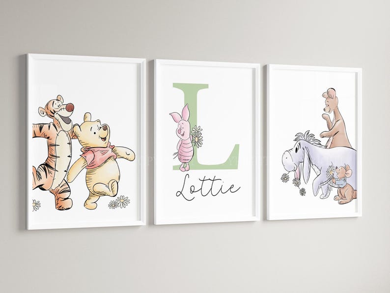 May include: Three white-framed wall art prints featuring Winnie the Pooh characters. The left print shows Tigger and Pooh. The center print displays a large green letter L, Piglet, and the name Lottie. The right print shows Eeyore, Kanga, and Roo.