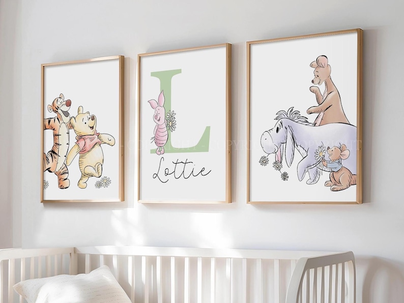 May include: Three framed wall art prints featuring Winnie the Pooh characters. The left print shows Tigger and Pooh. The center print displays a large green letter L with Piglet and the name Lottie. The right print shows Eeyore, Roo, and Roo.