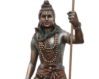 May include: A bronze statue of the Hindu deity Shiva, standing with a trident in his right hand and a small object in his left hand. He is wearing a snake around his neck and a tiger skin around his waist. The statue is on a brown base.