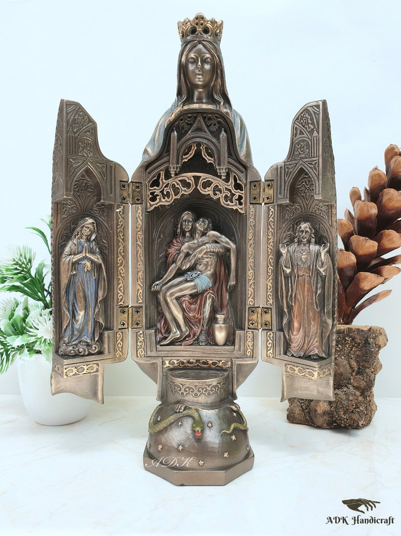 May include: A three-panel, bronze-colored, religious sculpture depicting the Virgin Mary, the Piet&agrave;, and Jesus Christ. The sculpture is intricately detailed with gold accents and features a snake on the base.