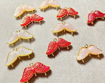 May include: Assortment of red and white iridescent angel wings charms with gold accents. The charms have a textured surface and are perfect for jewelry making or crafting.