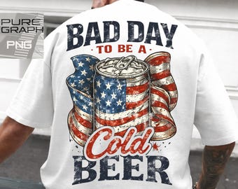 May include: White t-shirt with a graphic design on the back. The design features a beer can with an American flag motif and the words "BAD DAY TO BE A COLD BEER" in distressed lettering.