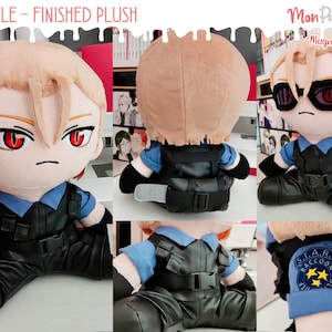 May include: A plush toy of a character wearing a blue shirt, black pants, and a black vest with a belt. The character has blonde hair, red eyes, and black sunglasses. The toy is sitting down with its legs crossed. The text "S.T.A.R.S. Raccoon City Police" is on the left arm of the toy.