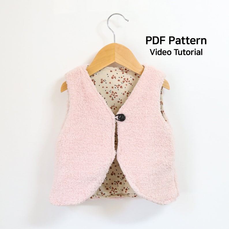 May include: A pink fleece vest with a floral print lining. The vest has a button closure and is hanging on a wooden hanger. The text "PDF Pattern Video Tutorial" is visible at the top of the image.