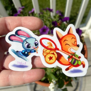 May include: A sticker featuring a cartoon fox and rabbit. The fox is wearing a green shirt and carrying a net. The rabbit is wearing a blue shirt and holding a slingshot. The sticker is on a white background.