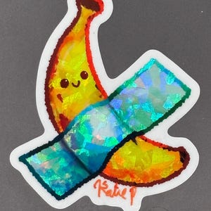 Peut inclure: Une banane jaune avec un visage souriant est enveloppée d'un bandage iridescent bleu. La banane est dessinée dans un style cartoon avec un contour rouge. Le bandage est un autocollant holographique avec une finition iridescente bleue et verte. L'autocollant est signé "Katie P".