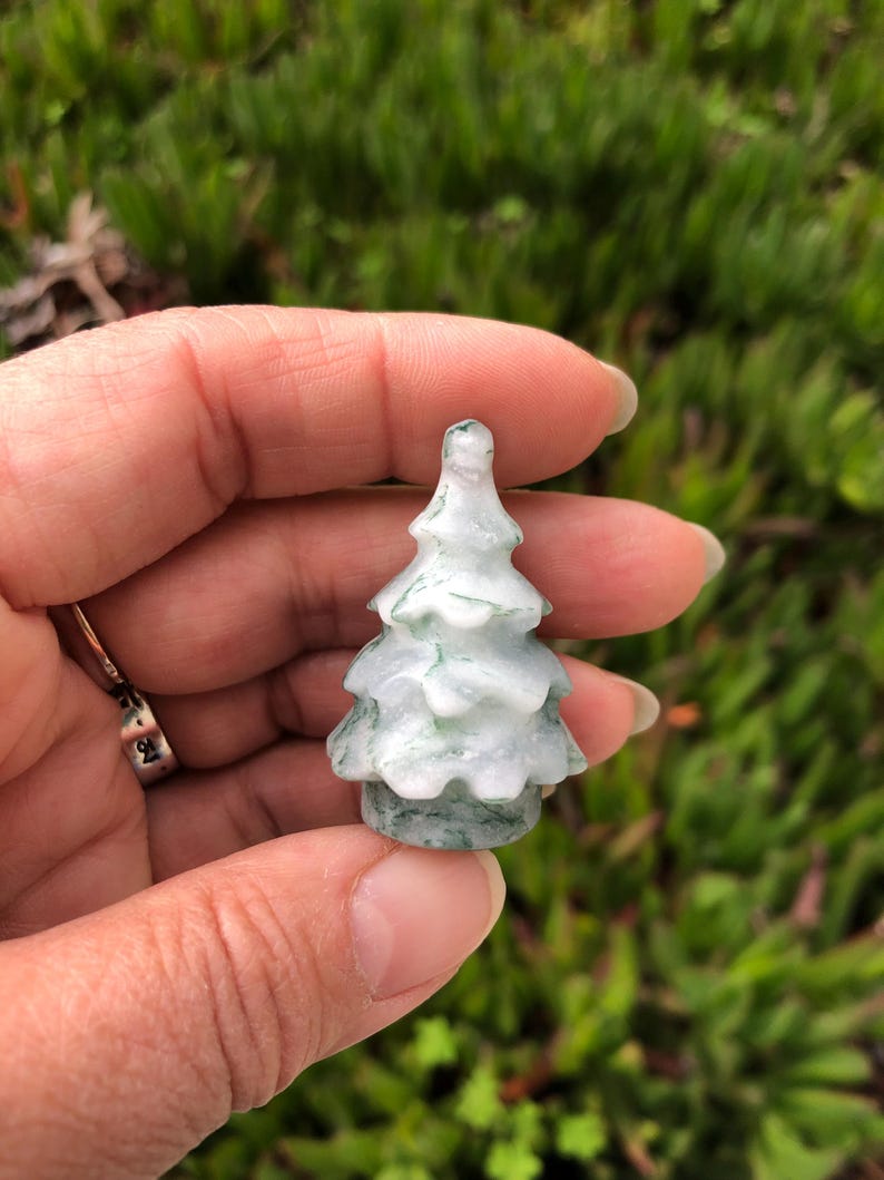 May include: A small, carved green and white jade tree figurine. The tree is about 2 inches tall and has a detailed, realistic design.