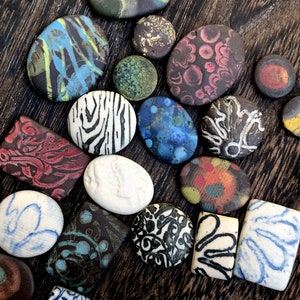 Puede incluir: Surtido de azulejos de cerámica coloridos con varios patrones y diseños. Los azulejos son principalmente redondos, con algunas formas cuadradas y rectangulares. Los azulejos presentan patrones abstractos, diseños florales y formas geométricas.