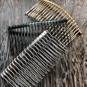 Peut inclure: Trois peignes à cheveux de différentes couleurs : or, noir et argent. Les peignes sont en métal et ont un design décoratif.