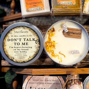 Op de afbeelding: Een witte kaars in een ronde, zilveren metalen pot. De tekst op de pot luidt: "Als deze kaars brandt, PRAAT NIET MET MIJ." De kaars is versierd met gedroogde bloemen en een klein label. De kaars is veganistisch, van soja en plasticvrij. 250 ml.