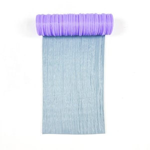 Puede incluir: Vista superior de un artículo de manualidades. El artículo presenta un cilindro morado lavanda, estriado, unido a una lámina rectangular azul claro texturizada. El fondo es blanco liso.