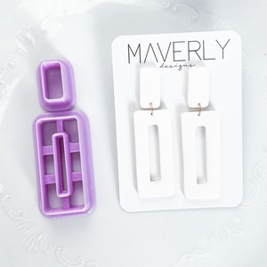 May include: White rectangular earrings with gold-coloured hooks on a white card with "MAVERLY designs". A purple polymer clay cutter, matching the earring shape, is also visible.
