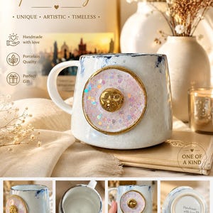 Pode incluir: Uma caneca de porcelana branca com acabamento texturizado e borda azul. A frente apresenta um medalhão circular com um rosto de sol dourado sobre um fundo rosa pálido com brilhos, emoldurado por uma borda de cor dourada.