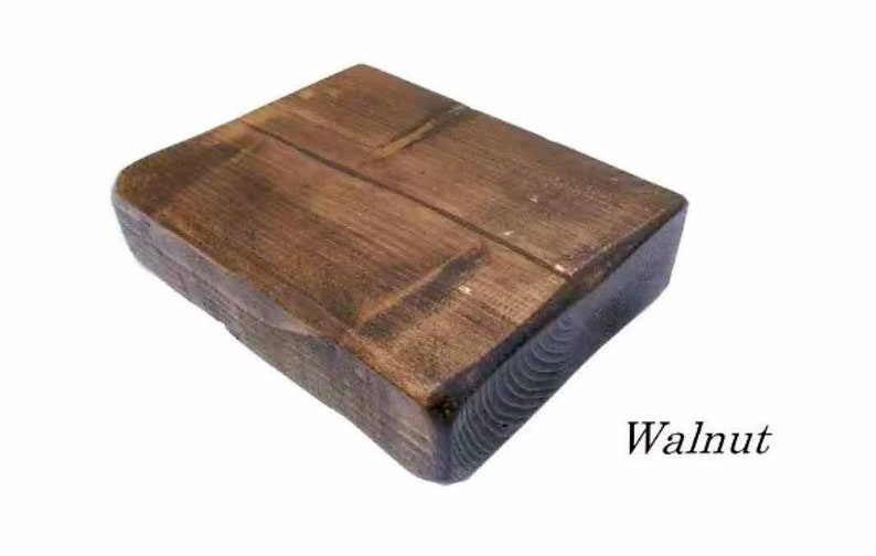 May include: A rectangular wooden block with a dark walnut stain. The wood grain is visible and the edges are rounded. The block is sitting on a white background. Walnut.