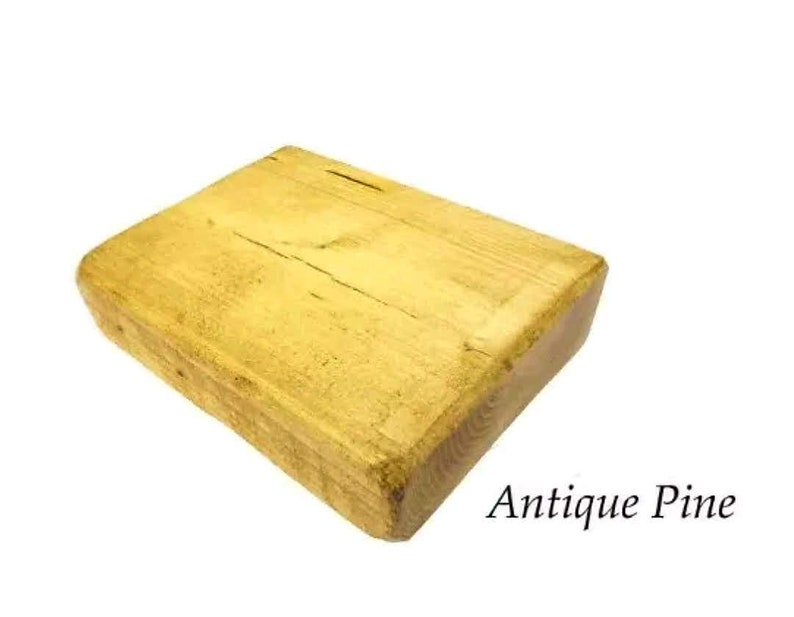 May include: A rectangular block of wood with a light yellow finish. The wood has a natural grain pattern and is labeled "Antique Pine".