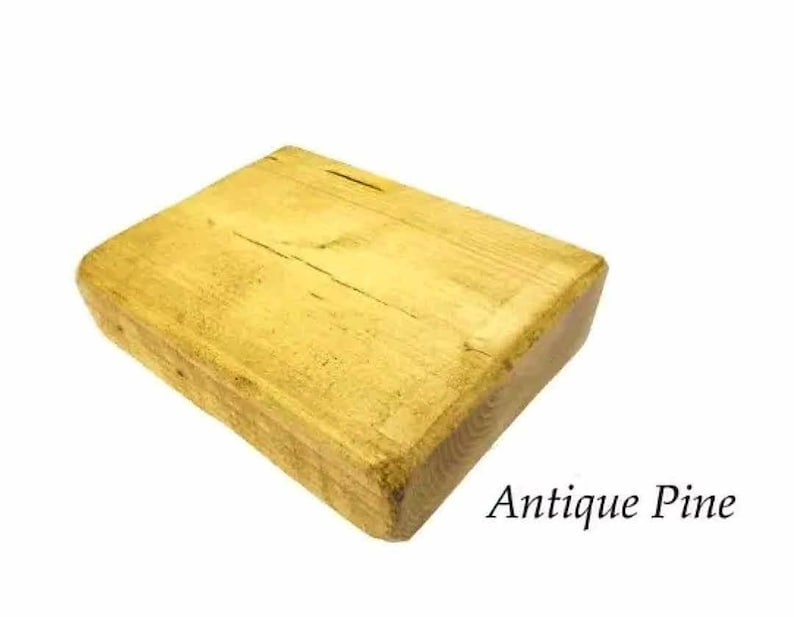 May include: A rectangular block of wood with a light yellow finish. The wood has a natural grain pattern and is labeled "Antique Pine".