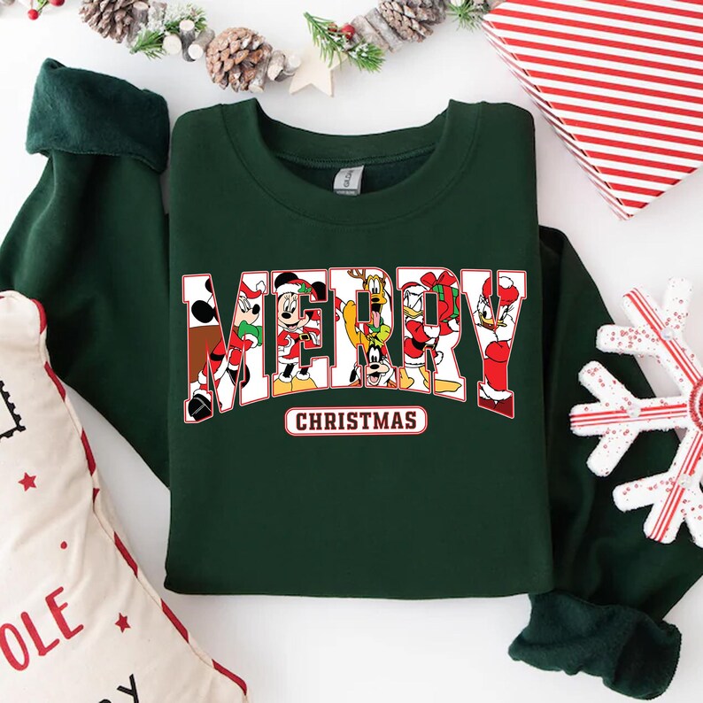 May include: A dark green sweatshirt with a white "Merry Christmas" graphic featuring Mickey Mouse, Minnie Mouse, Donald Duck, Goofy, and Pluto.