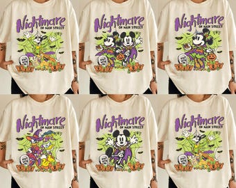 May include: Six white t-shirts with a purple and green graphic print of Mickey Mouse and a spider web. The text "Nightmare on Main Street" is printed on each shirt.