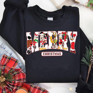 May include: Black sweatshirt with a red and white "Merry Christmas" graphic featuring Mickey Mouse, Minnie Mouse, Donald Duck, Goofy, and Pluto.