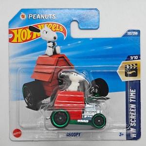 Op de afbeelding: Een rode Hot Wheels auto met een groen-wit ontwerp met Snoopy van Peanuts. De auto staat op een blauwe en witte kaart met de tekst "Hot Wheels", "Peanuts", "Snoopy" en "HW Screen Time".