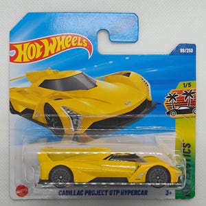 Könnte beinhalten: Gelbes Spielzeugauto aus Metallguss, ein Cadillac Project GTP Hypercar, aus der Hot Wheels-Serie. Das Auto befindet sich auf einem blauen Hintergrund mit dem Hot Wheels-Logo und den Worten "1/5" und "99/250".