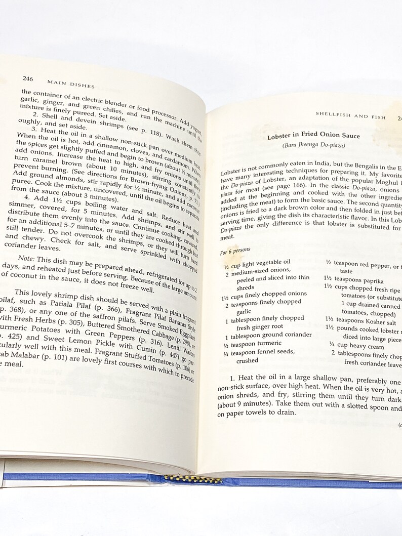 May include: A page from a cookbook with a recipe for Lobster in Fried Onion Sauce. The recipe includes a list of ingredients and instructions for preparing the dish. The text includes the name of the dish in both English and Hindi.