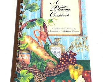 May include: A spiral-bound cookbook titled "A Palate Pleasing Cookbook" with a basket of produce on the cover. The cover art includes a carrot, cucumber, wheat flour, apples, and grapes. The text "A Collection of Recipes by Atascocita Presbyterian Women" is also visible.