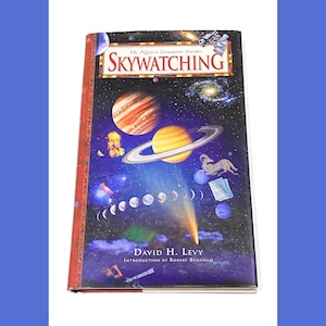 May include: A book titled "Skywatching" by David H. Levy, part of The Nature Company Guides series. The cover features a colorful illustration of planets, stars, and a comet against a dark blue background.