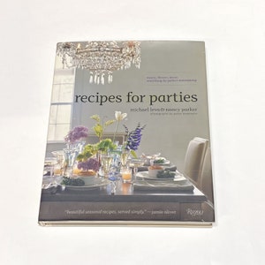 May include: A cookbook titled "Recipes for Parties" by Michael Leva & Nancy Parker. The cover features a photograph of a beautifully set table with flowers, candles, and a crystal chandelier.