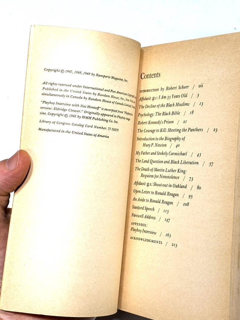 May include: Open book with text. The left page has copyright information. The right page displays a table of contents, including "Playboy Interview" and "Robert Kennedy's Prison". The book is held open by a hand.