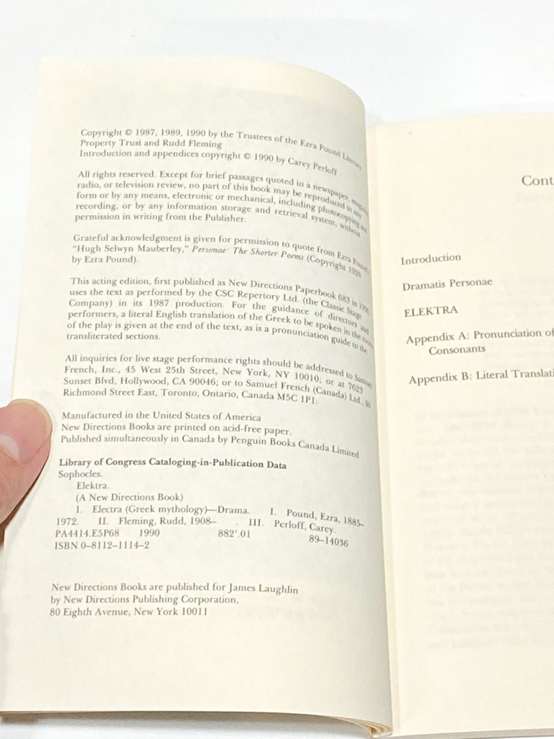 以下が含まれることがあります： ソフォクレスの「エレクトラ」というタイトルの書籍の表紙。この書籍はニュー・ダイレクションズ・ブックシリーズの一部であり、女性の顔の白黒イラストが描かれている。