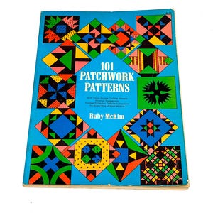 May include: A vintage book titled "101 Patchwork Patterns" by Ruby McKim. The cover is a vibrant blue with colorful geometric quilt block designs in red, yellow, green, and black. The book provides quilt name stories, cutting designs, and yardage estimates.