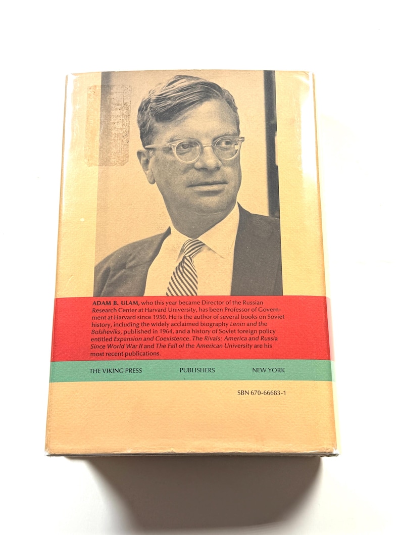 Puede incluir: Una portada de libro vintage con un retrato en blanco y negro de un hombre con gafas y corbata. La portada incluye texto con el nombre del autor, el t&iacute;tulo del libro y la informaci&oacute;n del editor. El fondo es una mezcla de beige, rojo y verde.