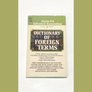 May include: A yellow and white book cover with the title "A Dictionary of Foreign Terms" by Mario Pei and Salvatore Ramondino. The book cover features a guide to the use of the dictionary, a list of abbreviations, a pronunciation key, and a fully cross-referenced index.