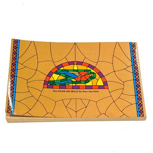 The image is a book cover with a colorful stained glass design featuring a bird and the text "Say GAR-AB Delly for inner chocolate".