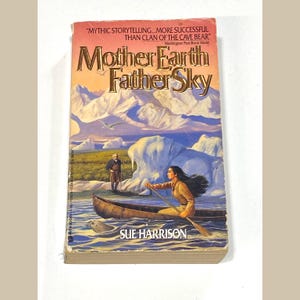 May include: A paperback book titled "Mother Earth Father Sky" by Sue Harrison. The cover art depicts a woman in a canoe, mountains, and the text "Mythic Storytelling...More Successful Than Clan of the Cave Bear". The book has a vintage aesthetic.