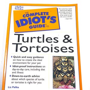 May include: A paperback book titled The Complete Idiot's Guide to Turtles & Tortoises by Liz Palika. The cover features a yellow rectangular graphic with the title in blue text, a poem by Ogden Nash, and a photograph of a patterned tortoise.