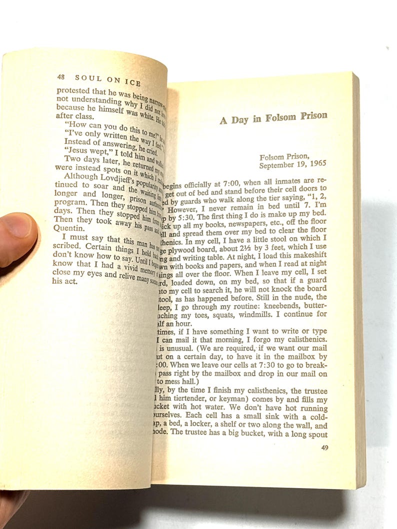 May include: An open book with text on the pages. The left page has the title "SOUL ON ICE" and the number 48. The right page has the title "A Day in Folsom Prison" and the date "September 19, 1965".