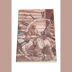 May include: Book cover with a clock face and the title "Mastered by the Clock: Time, Slavery, and Freedom in the American South" by Mark M. Smith.
