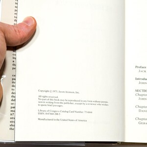 a person holding a book with text printed on the pages.