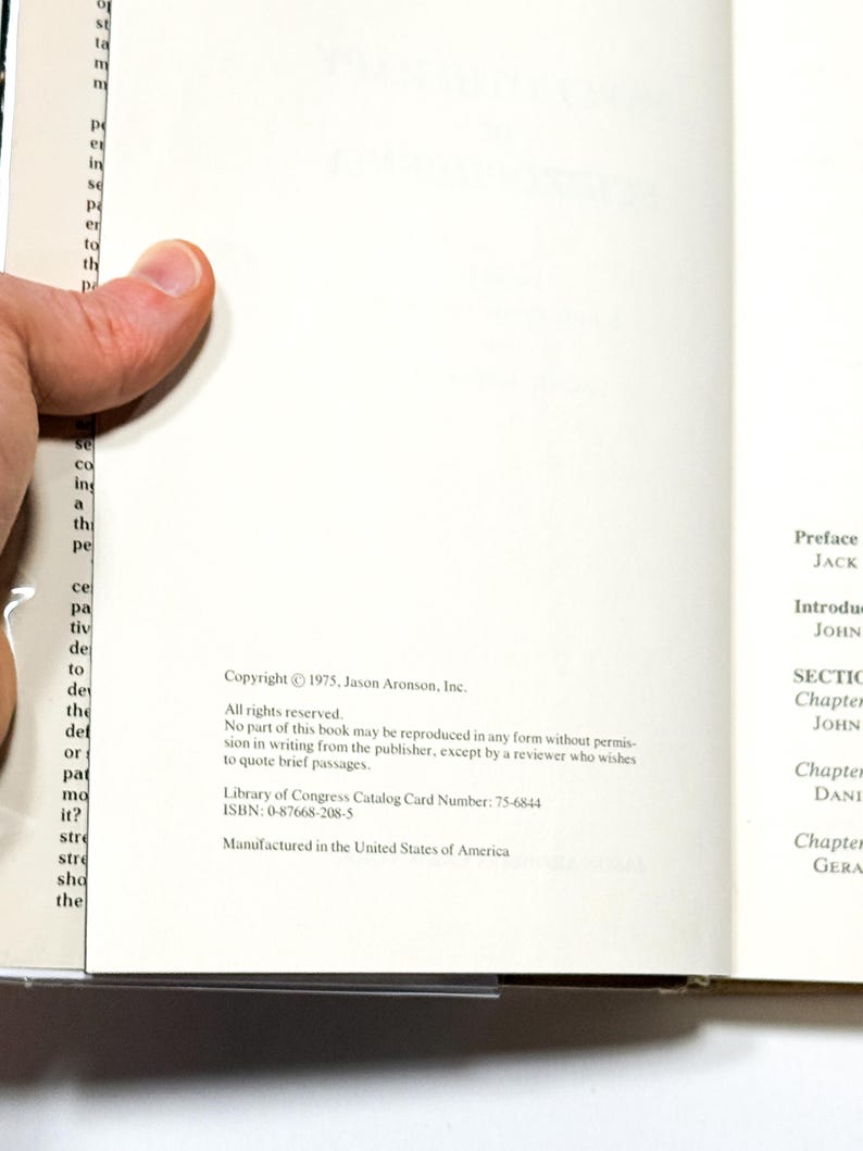 a person holding a book with text printed on the pages.