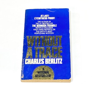May include: A blue paperback book with a gold title "Without a Trace" by Charles Berlitz. The book cover also features the text "At Last! Eyewitness Proof!" and "A National Bestseller!"