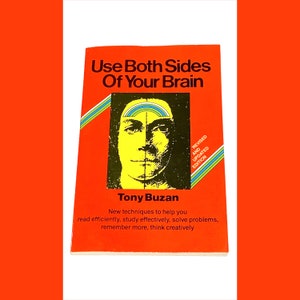 May include: A vintage book titled "Use Both Sides Of Your Brain" by Tony Buzan. The cover is orange with a graphic of a face split in half, one side yellow, the other black. Text includes "Revised and Updated Edition."