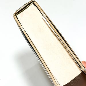 a close-up view of the spine of a book, with a gold-colored metal frame.