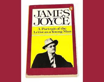 May include: A red and yellow paperback book with the title "JAMES JOYCE A Portrait of the Artist as a Young Man". The cover features a black and white photo of a man wearing a hat and glasses.